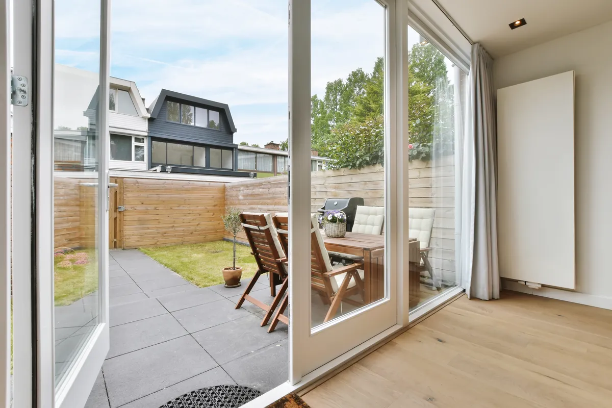 Aluminium bi-fold doors open onto a paved patio and garden