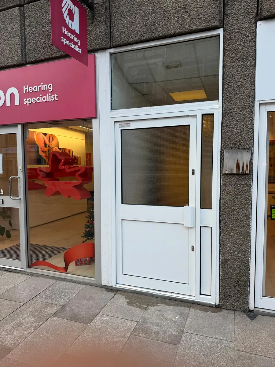White aluminium commercial entrance door on a London shopfront by Range Shop Fronts