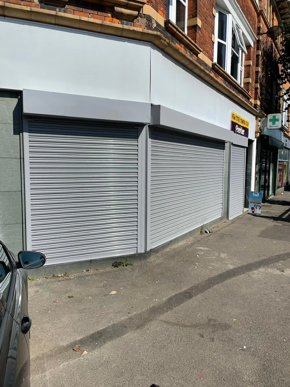 White roller shutter on a London corner shopfront