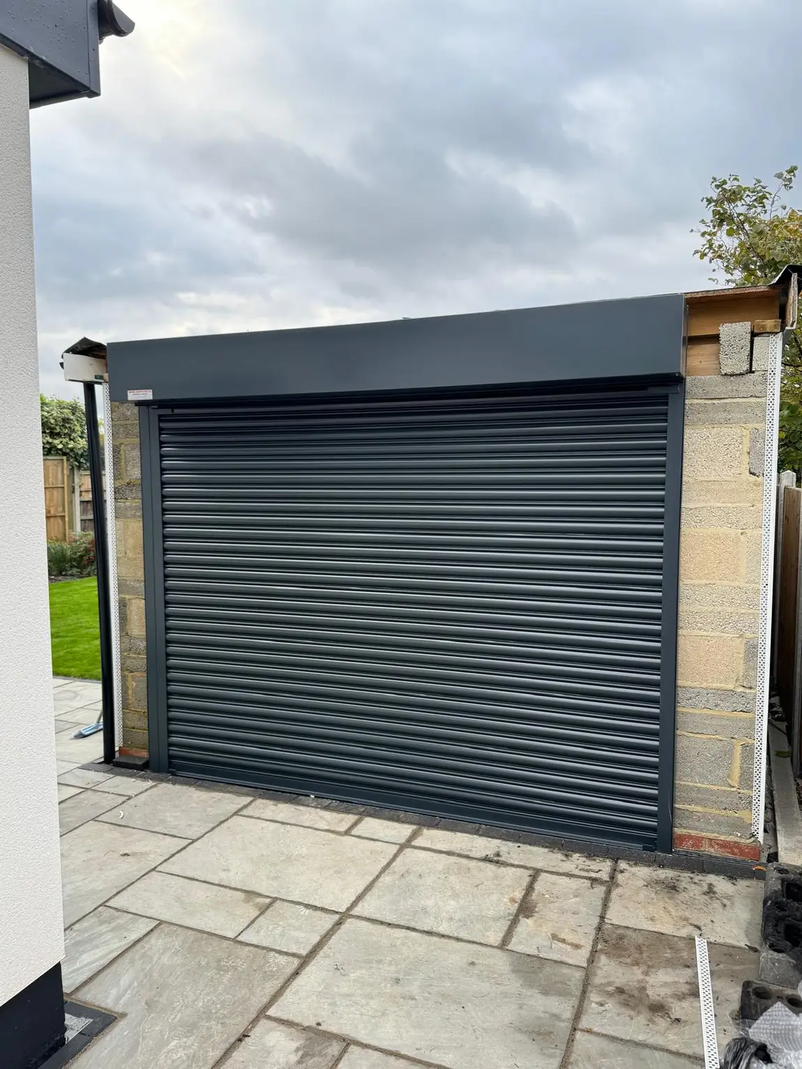 Colour-matched anthracite roller garage door on a paved driveway