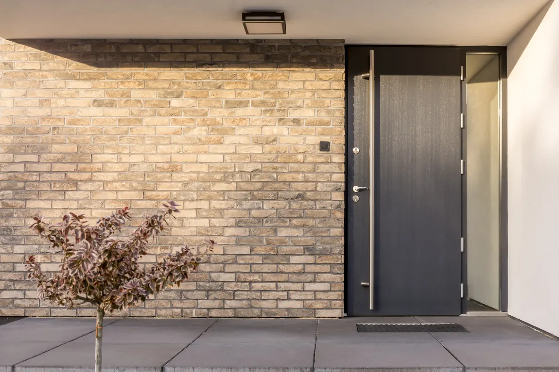 Anthracite steel entrance door on a modern brick home