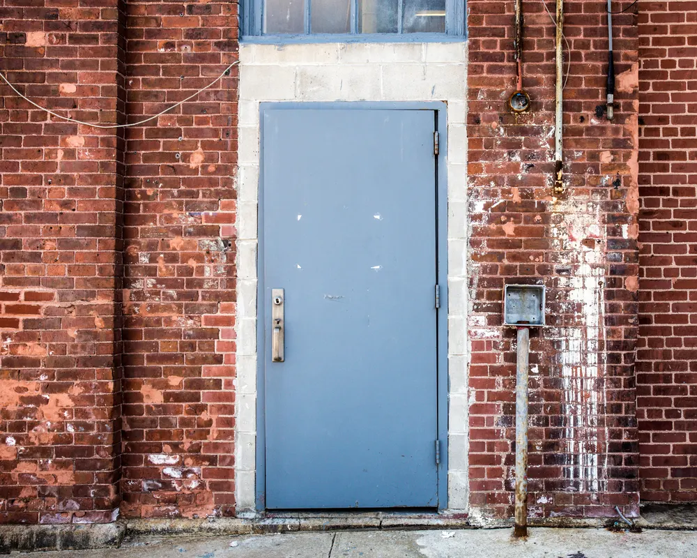 Steel security door installed in an industrial brick wall